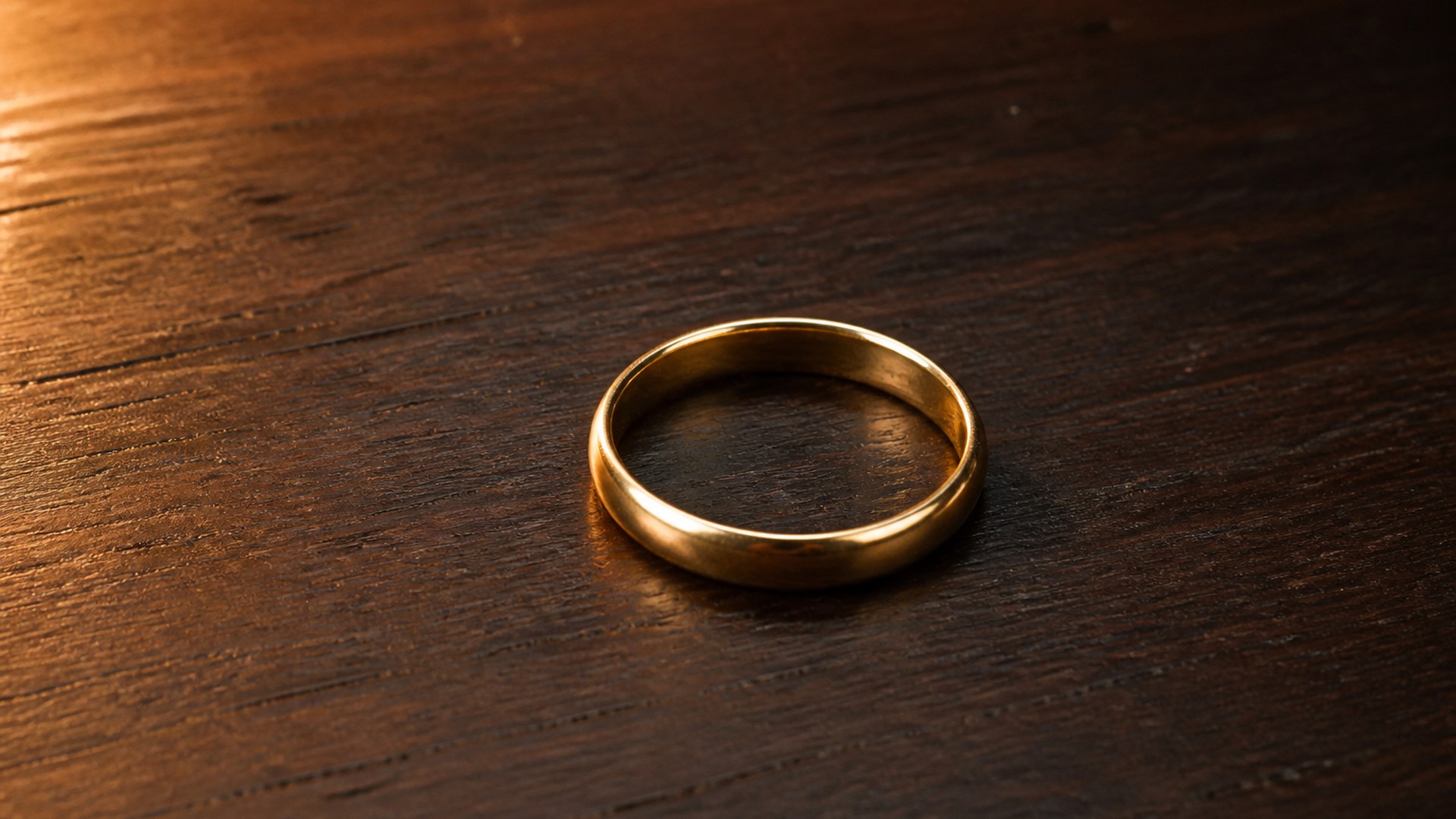 An incomplete ring of pale light on a dark field, a gap left open on one side, dust in the air