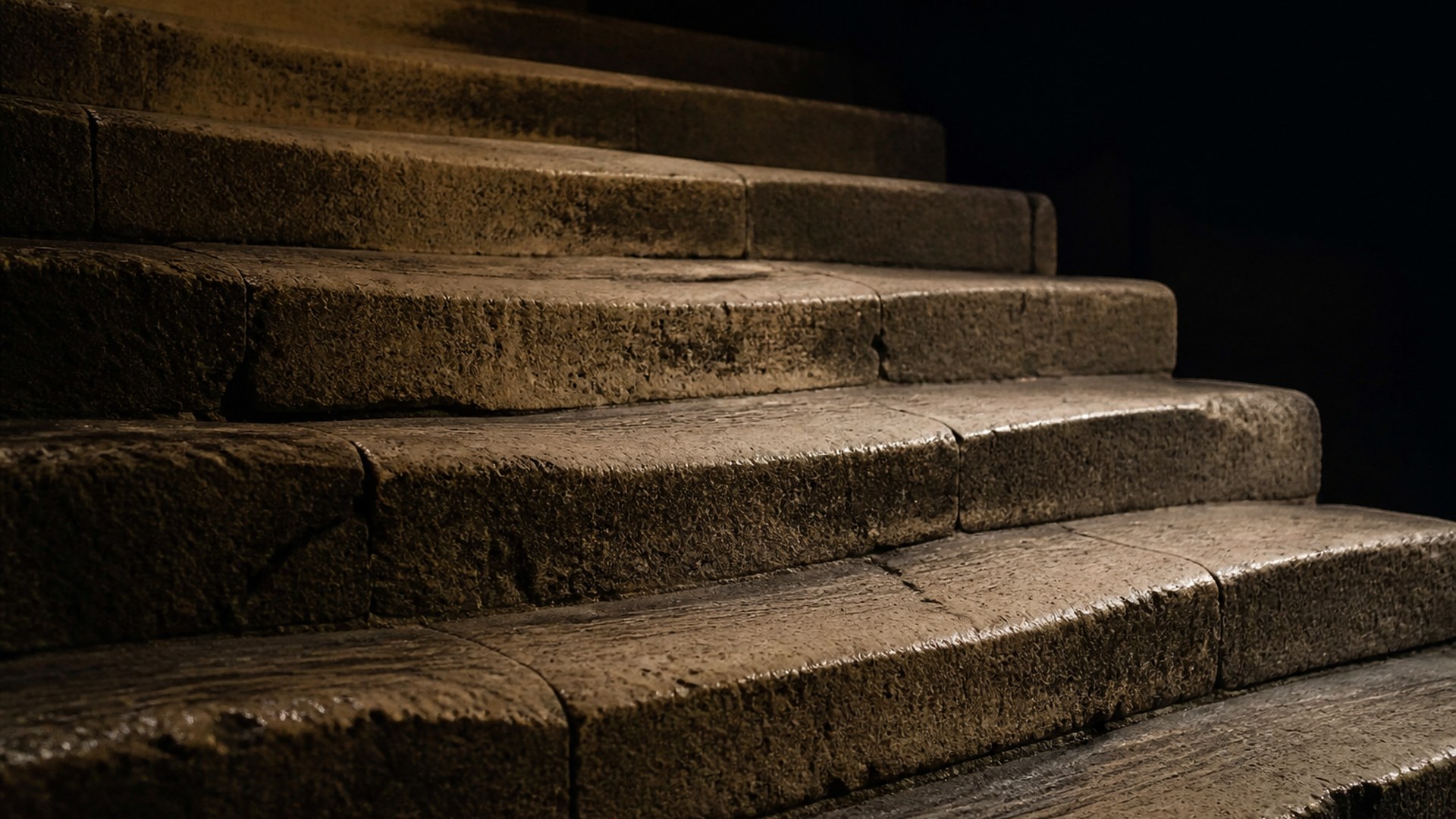 Concentric worn rings on a dark floor, dust hanging in a faint wash of light